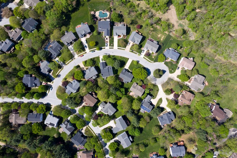 Aerial view of a curving residential street of single-family homes